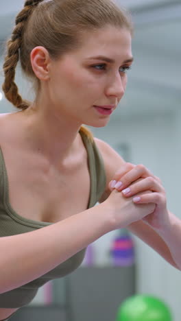 primer plano de una mujer con un traje verde y otra con marrón, ambas involucradas en una sesión de entrenamiento en un gimnasio, el enfoque está en su intensa concentración y forma