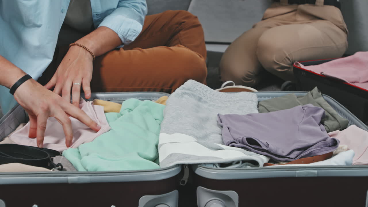 Couple Packing Suitcase And Preparing For Journey
