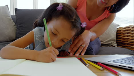 vista frontal de una madre negra madura ayudando a su hija con la tarea en un hogar cómodo 4k
