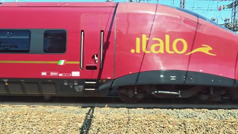 red train swiftly moves through scenic turin landscape