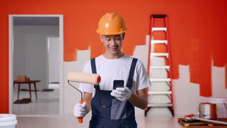 pintor que utiliza un teléfono inteligente durante la renovación