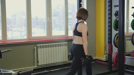 woman performing dumbbell exercises in a gym