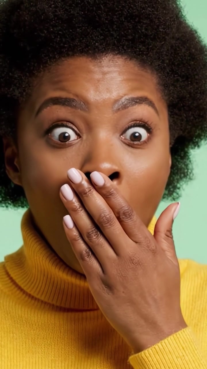 Astonished Expression: Capturing a Moment of Surprise in a Vibrant Yellow Turtleneck Against a Soft Green Background