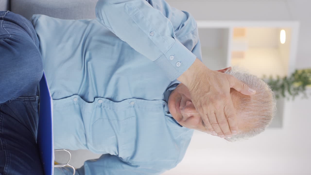 Vertikal video av Den gamle mannen som bekymrer seg over urettferdig papirarbeid