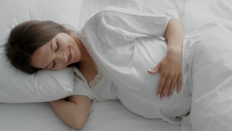 mujer embarazada descansando en la cama