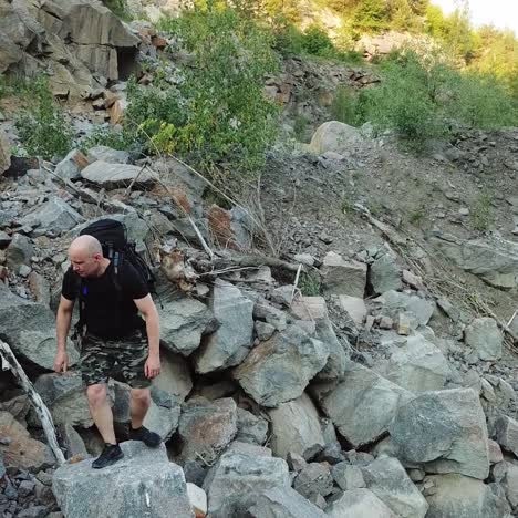 aerial view of a young man walking along a giant rocky mountain. traveler on the cliff. travel concept.