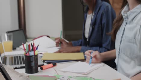 amigas adolescentes diversas que estudian en casa usando computadoras portátiles y tabletas