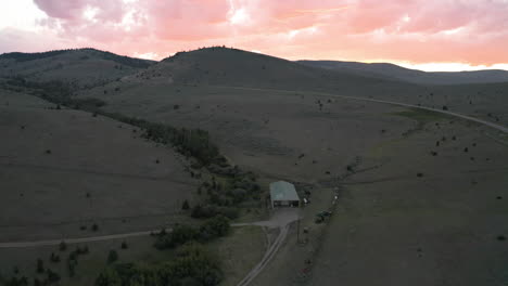 aerial high fly over drone footage with pink clouds in the horizon at montana mountain pass road, montana, usa