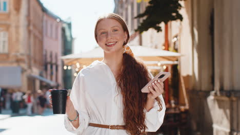 Teen girl woman enjoying drinking morning coffee hot drink relaxing taking a break in city street