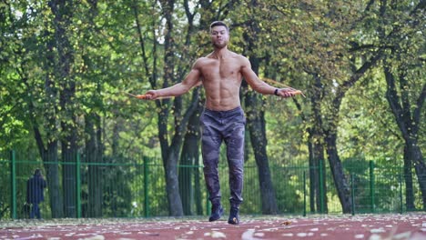 athlete doing exercise at stadium. active caucasian sportsman with skipping rope exercising on racetrack