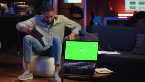 vertical video black young relaxed person having green screen in his trendy loft