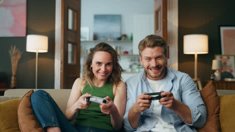 overjoyed friends enjoy videogame activity home. carefree pair holding gamepads