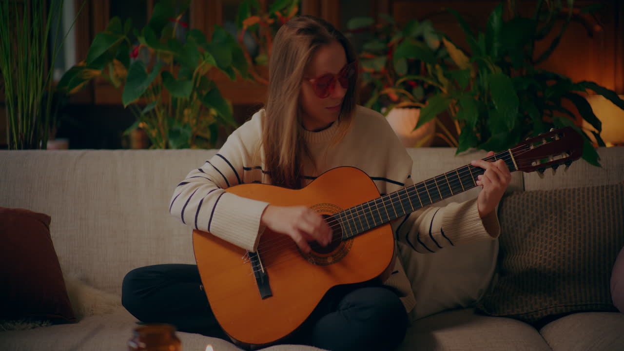 Kvinna spelar gitarr, skriver låt, komponerar musik