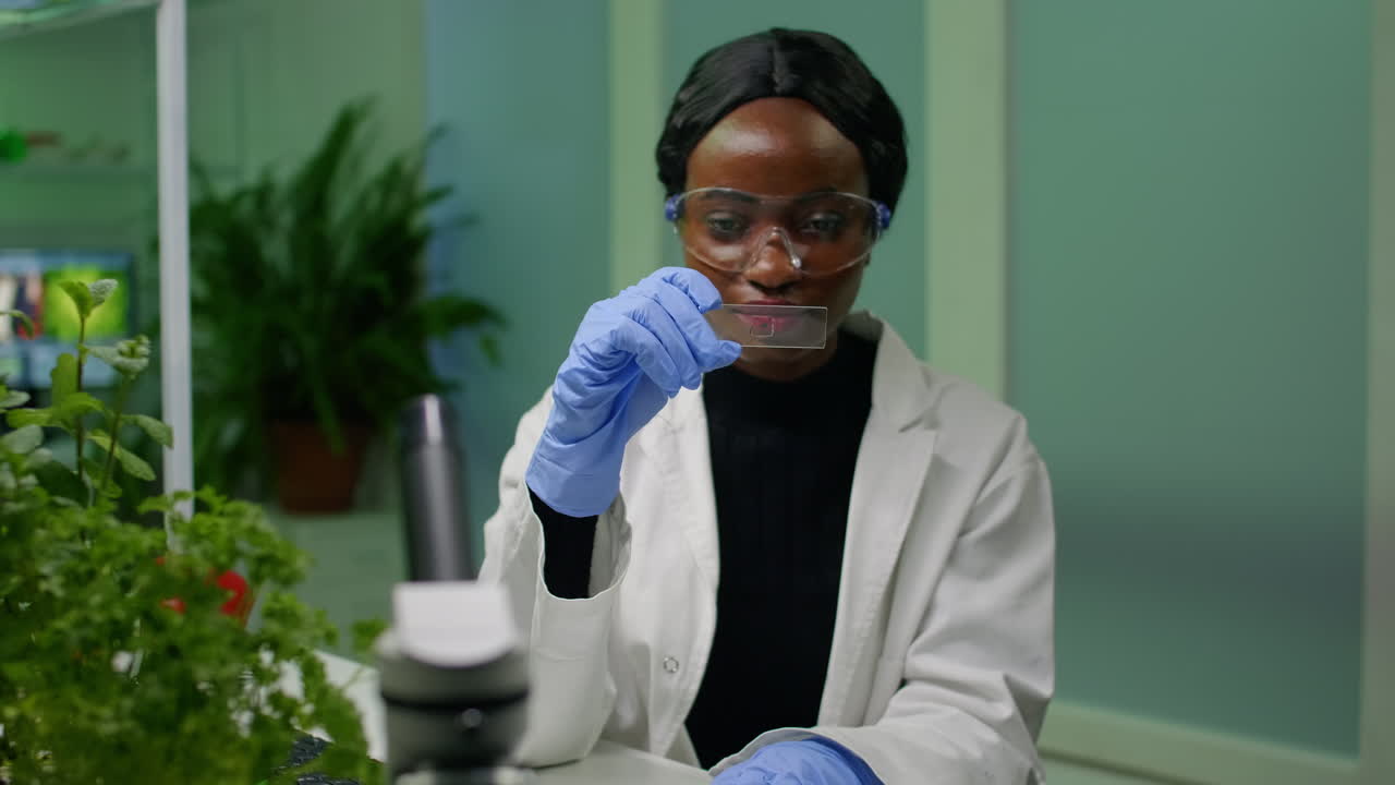 Botanist researcher scientist analyzing green liquid sample under microscope