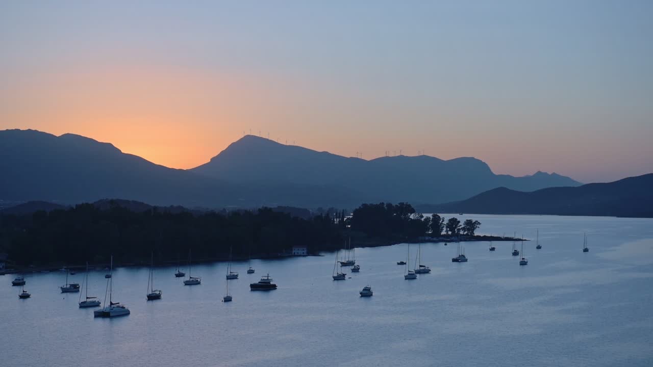 Panoramic landscape view of moored sailboats, near the greek coastline, at dusk