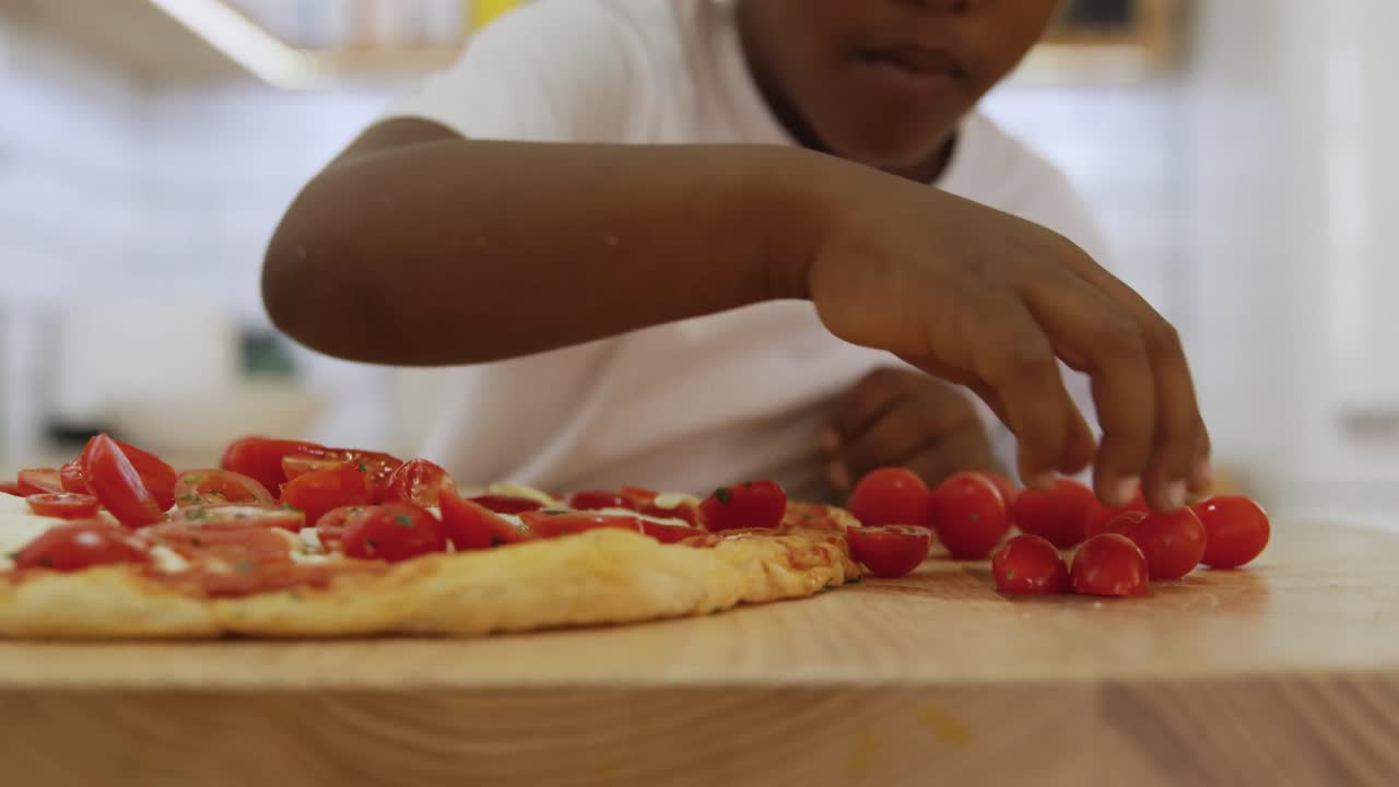 어린 소년이 집에서 피자를 만들고 있습니다.