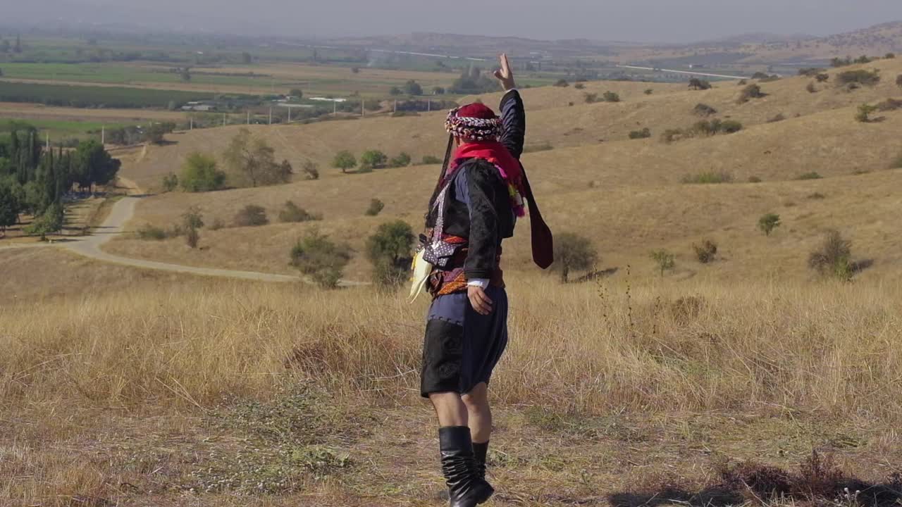 Man playing zeybek with local clothes