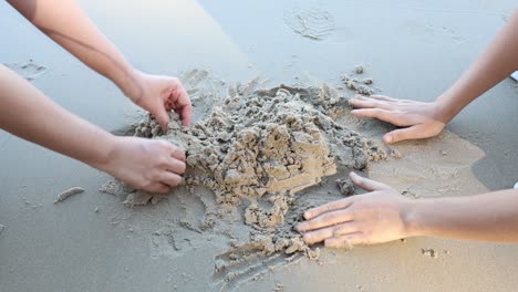 hands shaping and playing with sand