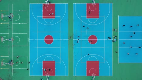 overhead view capturing people playing basketball in multipurpose sports court, creative aerial shot