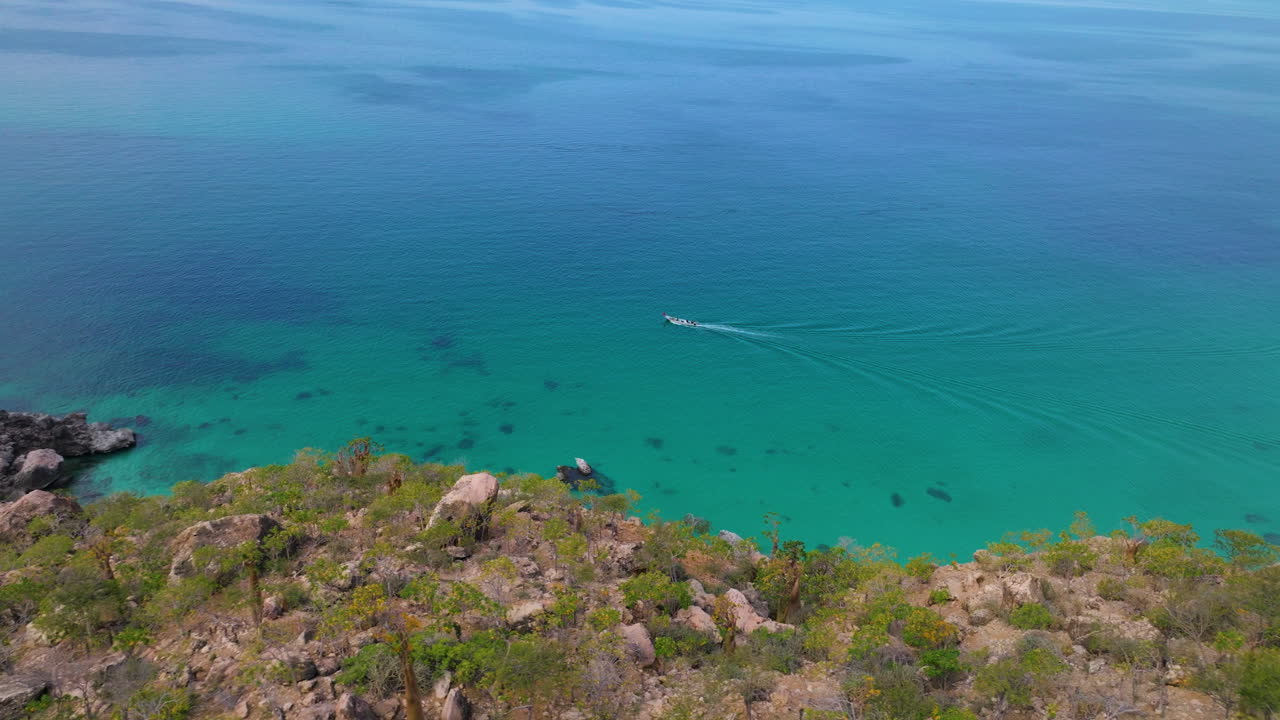 Shoab Coast With Boat Navigating In The Calm, Clear, Blue Water In Socotra Island, Yemen. - aerial shot