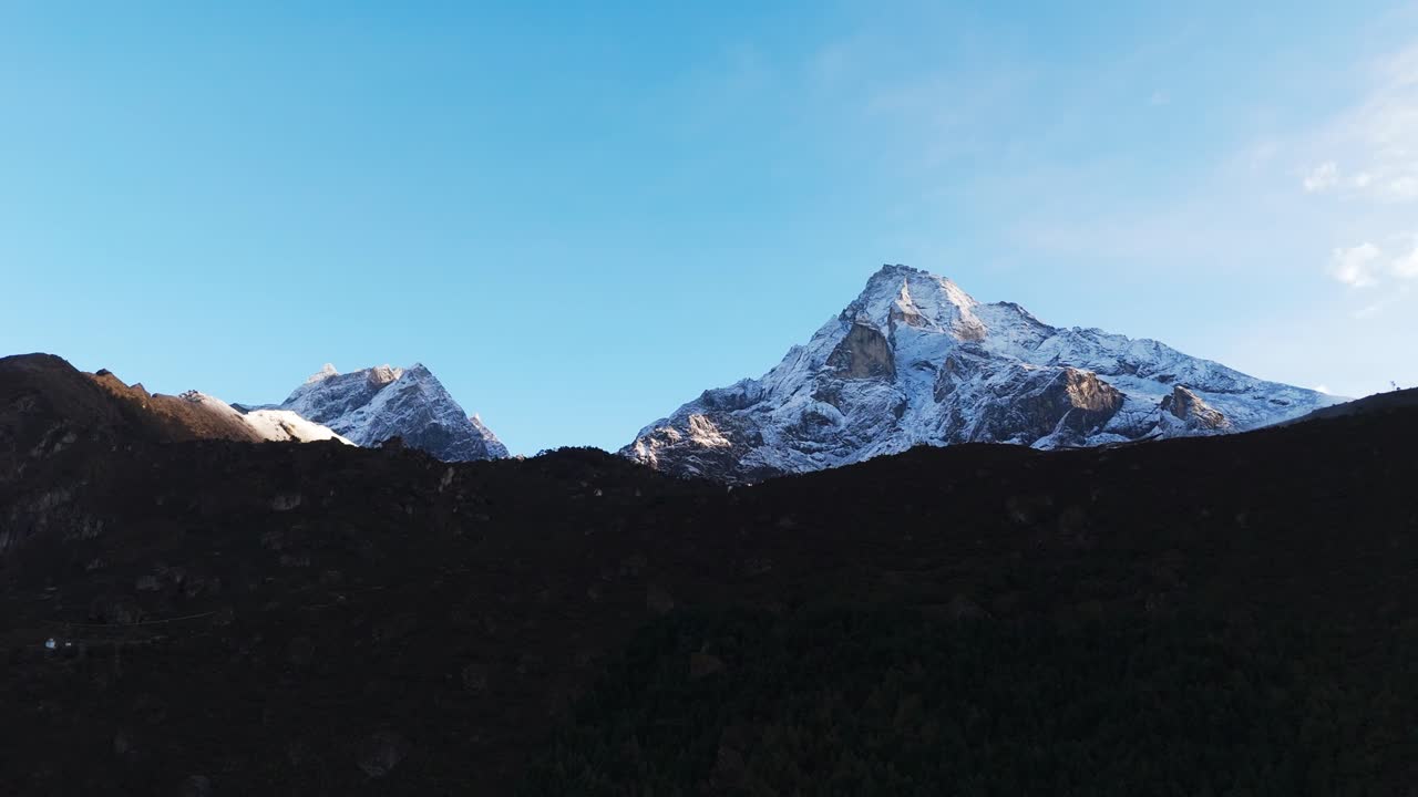 Towering Himalayan mountains frame the Everest Base Camp trekking route in Nepal, where trekkers experience breathtaking vistas of the world’s highest peaks along their high-altitude journey.