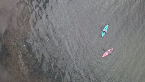 aerial bird's eye view over tourists kayaking in the lake at daytime