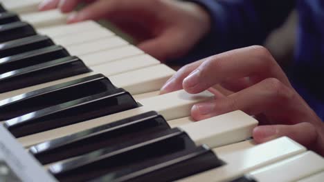primer plano de los dedos de un niño aprendiendo a tocar el piano 03