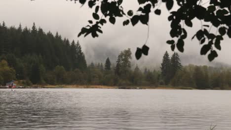 foggy scenery view of tranquil alta lake with gentle water ripples on the surface with windy and rainy weather, whistler bc