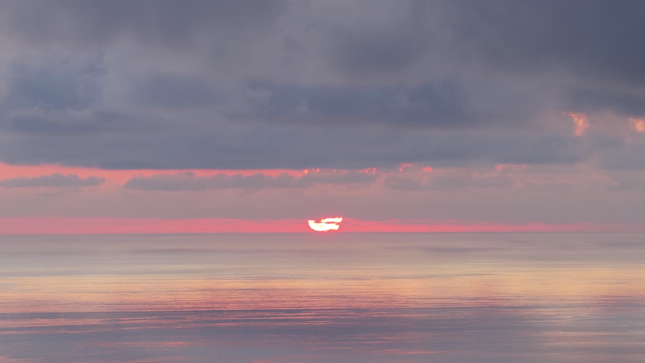 Tramonto vibrante che si riflette sull'acqua tranquilla dell'oceano