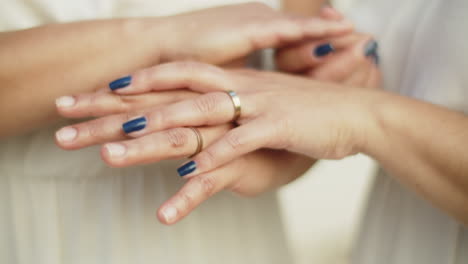 primer plano de las manos de una pareja de lesbianas con anillos de boda