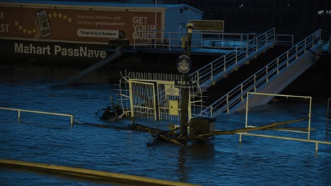 flooded pier entrance with submerged fencing and docked boats along the danube river in budapest, hungary, 2024