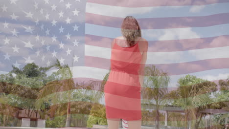 animation of american flag over happy caucasian mother and son dancing by sunny pool