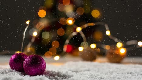Animation-of-christmas-bubbles-over-snow-and-bokeh-garlands