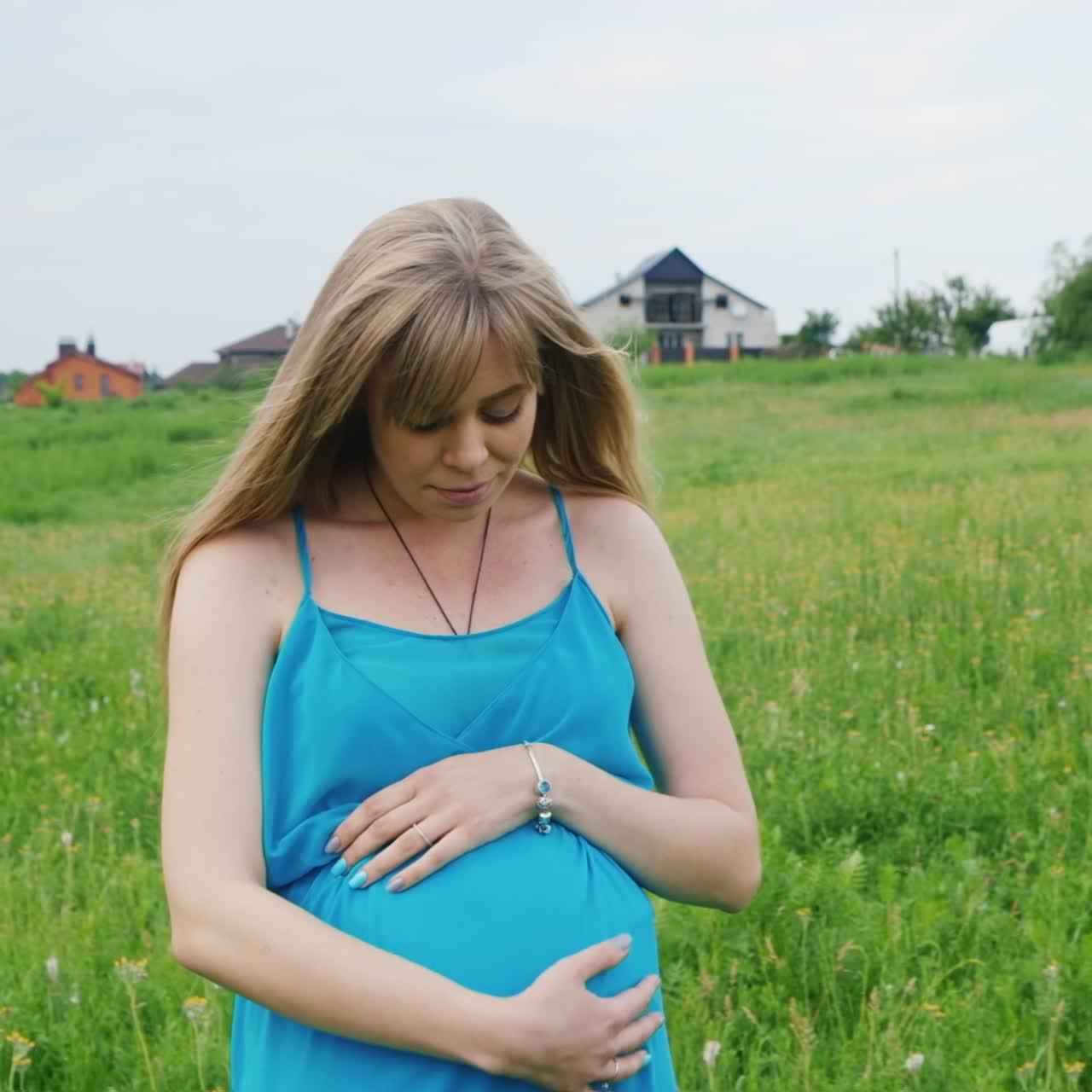 беременная женщина идет по лугу