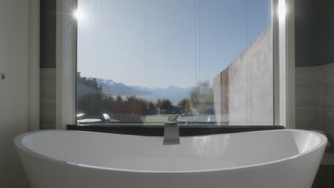 modern bath tub with stunning mountain and lake views