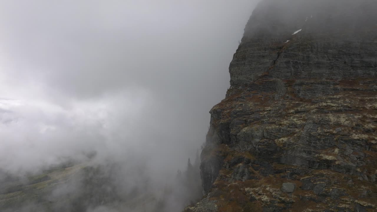 gran pared montañosa con nubes que la rodean, drones volando hacia las nubes