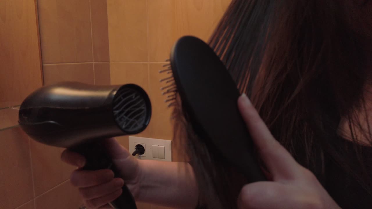 Hairdryer blow drying long brown hair held by brush, Slowmo Close Up