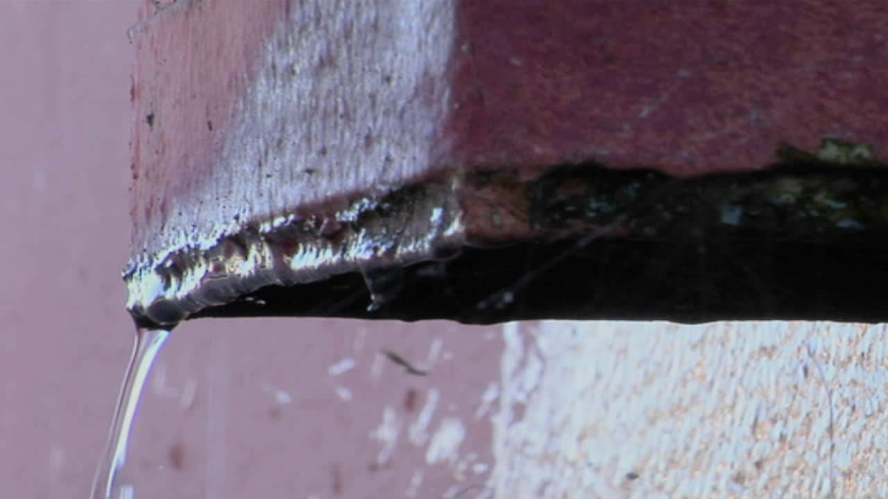 콘크리트 선반 가장자리에서 물이 떨어집니다.