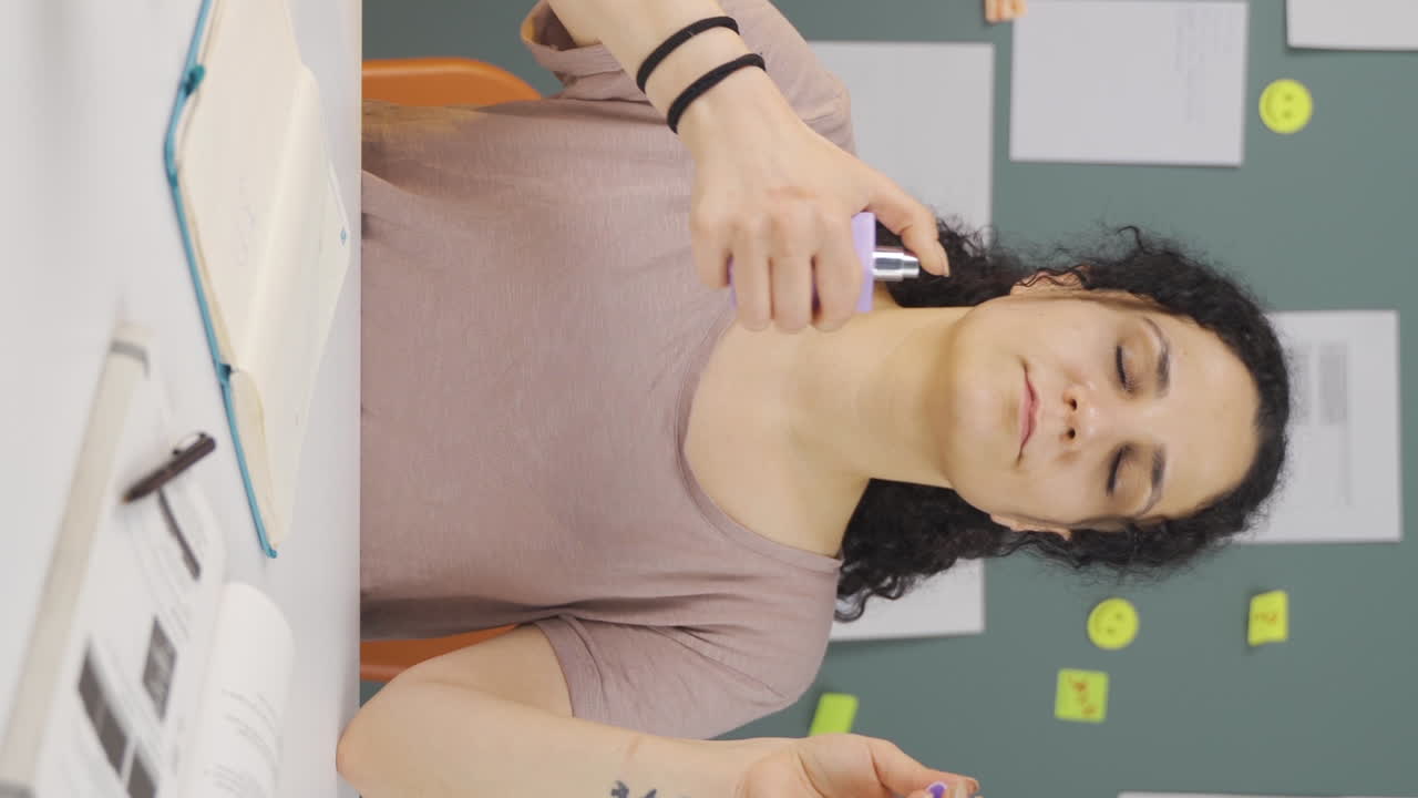video vertical de una estudiante rociando perfume.