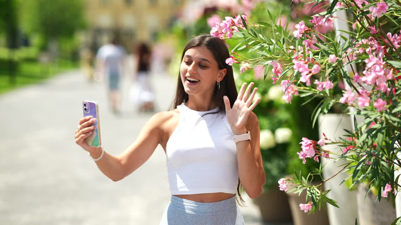 una mujer haciendo una llamada de video en un parque.