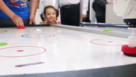 kids playing air hockey with robotic opponent