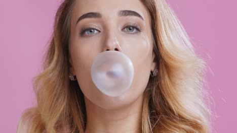 mujer soplando una burbuja de chicle