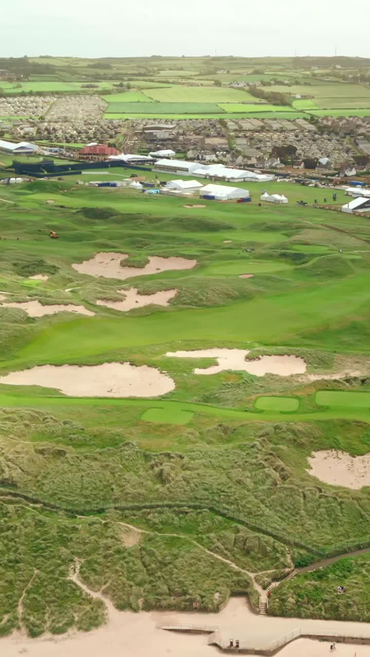 Right-to-left social ratio aerial video of Royal Portrush Golf Course in County Antrim, Northern Ireland, UK on a sunny day. Produced in 1080x1920 vertical ratio, 60FPS and with Rec709 color