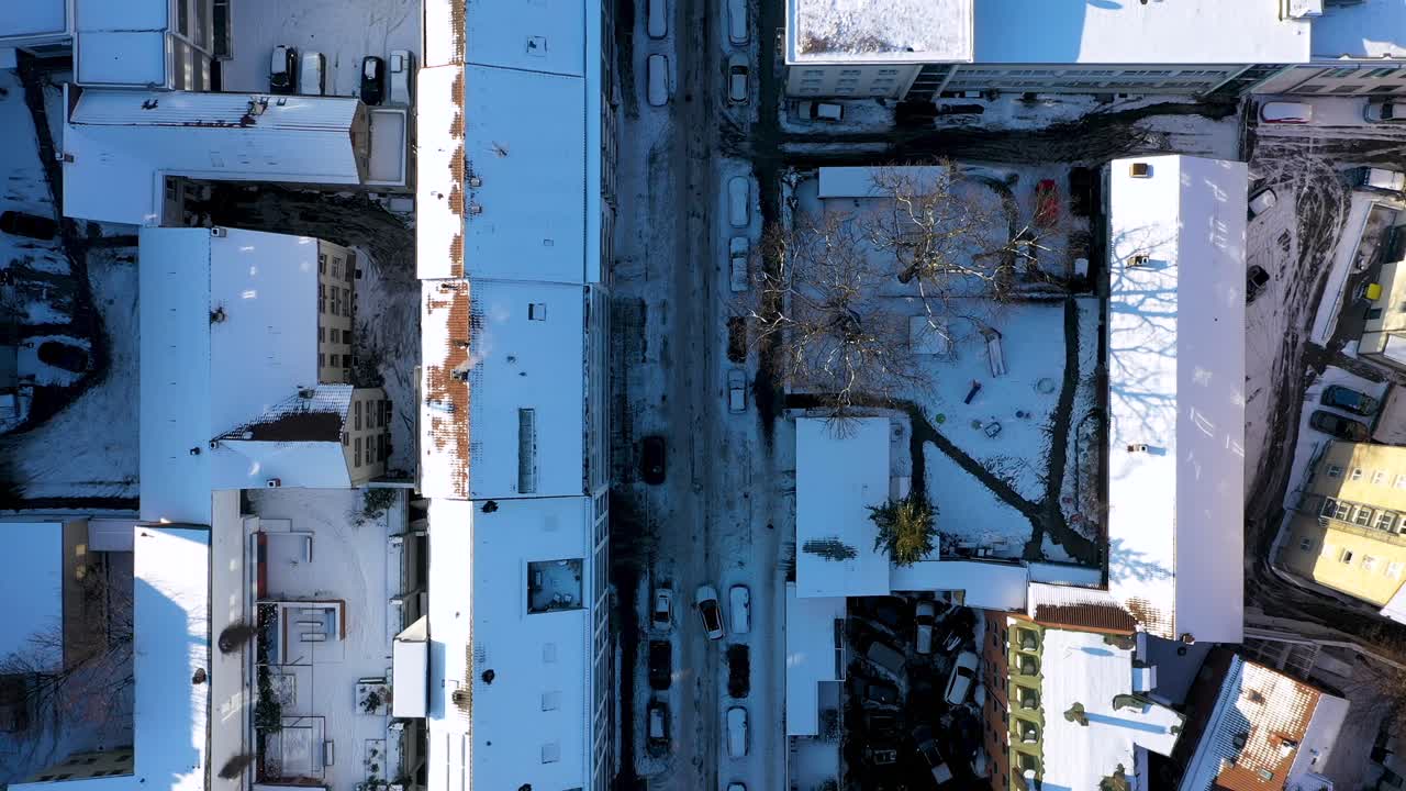 Aerial top down view of beautiful city center with red tile roofs and streets covered in snow and ice during winter in Stuttgart, Germany