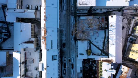 aerial top down view of beautiful city center with red tile roofs and streets covered in snow and ice during winter in stuttgart, germany