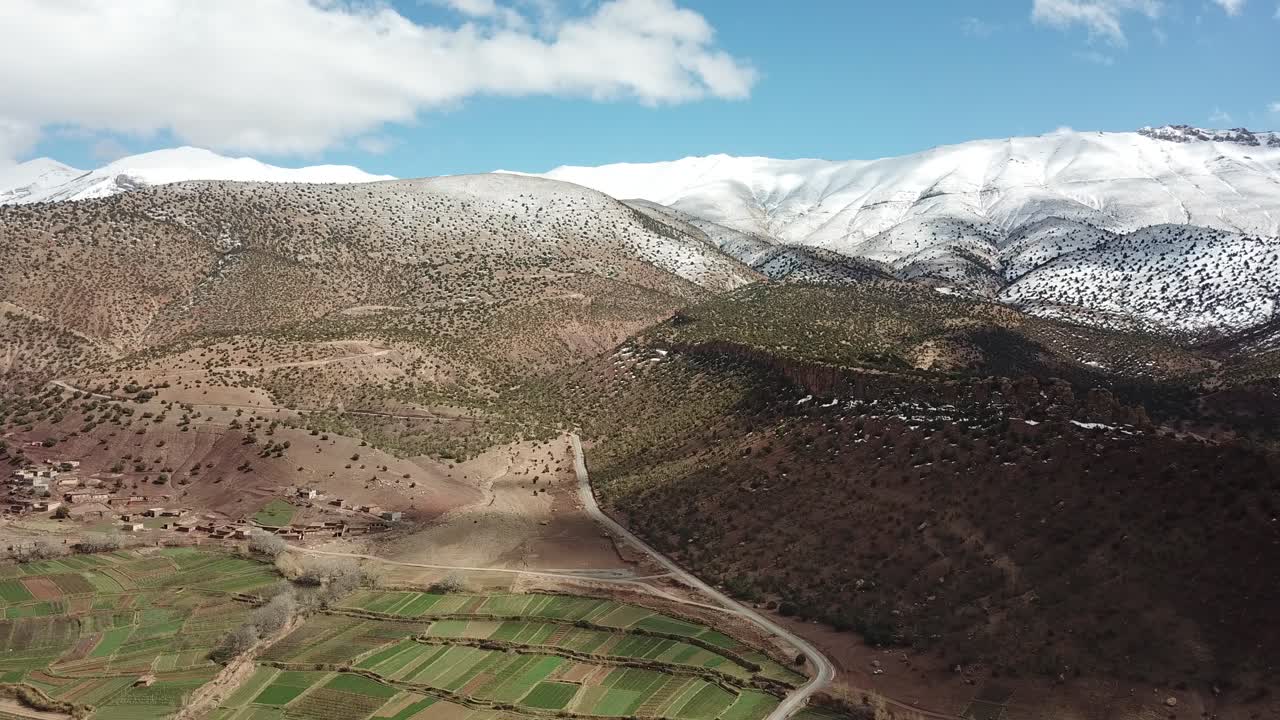 "White snow mantles Morocco's towering Atlas summits, creating a magnificent winter spectacle where icy caps gleam against clear skies and transform ancient peaks into frozen giants."