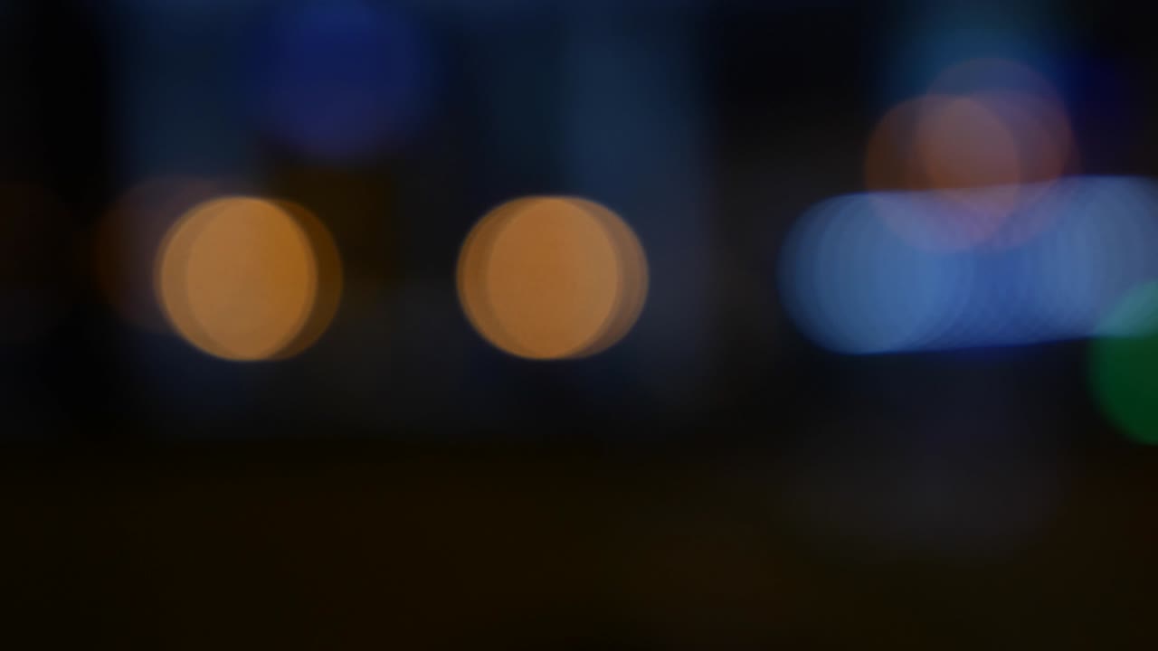 hermoso bokeh brillante en el fondo oscuro borroso por la noche. el redondo bokeh colorido brilla de las luces de los coches en la calle de la ciudad. fuera de foco con borroso. luces de la ciudad sin enfoque. bokeh de tráfico. concepto abstracto