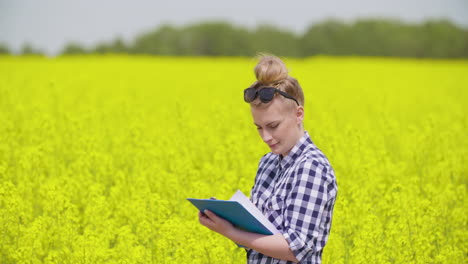 agricultora escribe notas en el campo agrícola