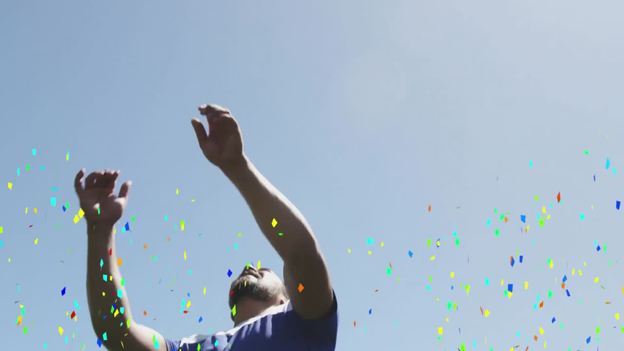 컬러풀한 콘페티가 남자 축구 선수에게 떨어지고 축구를 이끌고 있습니다.