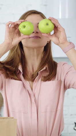 young girl closes her eyes with green apples. healthy eating. vertical video